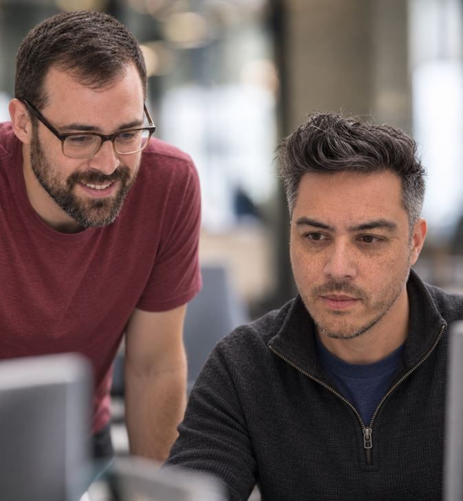 Two members of the SLIDEFACTORY team working at a laptop